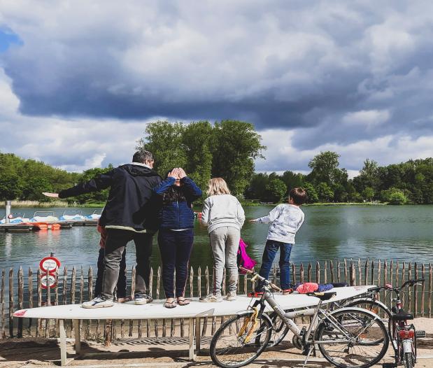Mensen aan een meer Vier mensen die op een surfplank staan en kijken naar een meer.